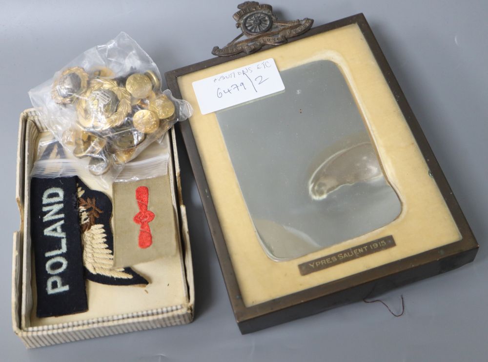 A framed First World War metal remnant with bullet indent Ypres Salient 1915 and assorted badges and buttons